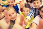 group of school kids showing thumbs up